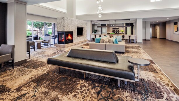 A spacious lobby with a fireplace, seating area, and a dining area. - Residence Inn Phoenix NW/Surprise (Surprise)