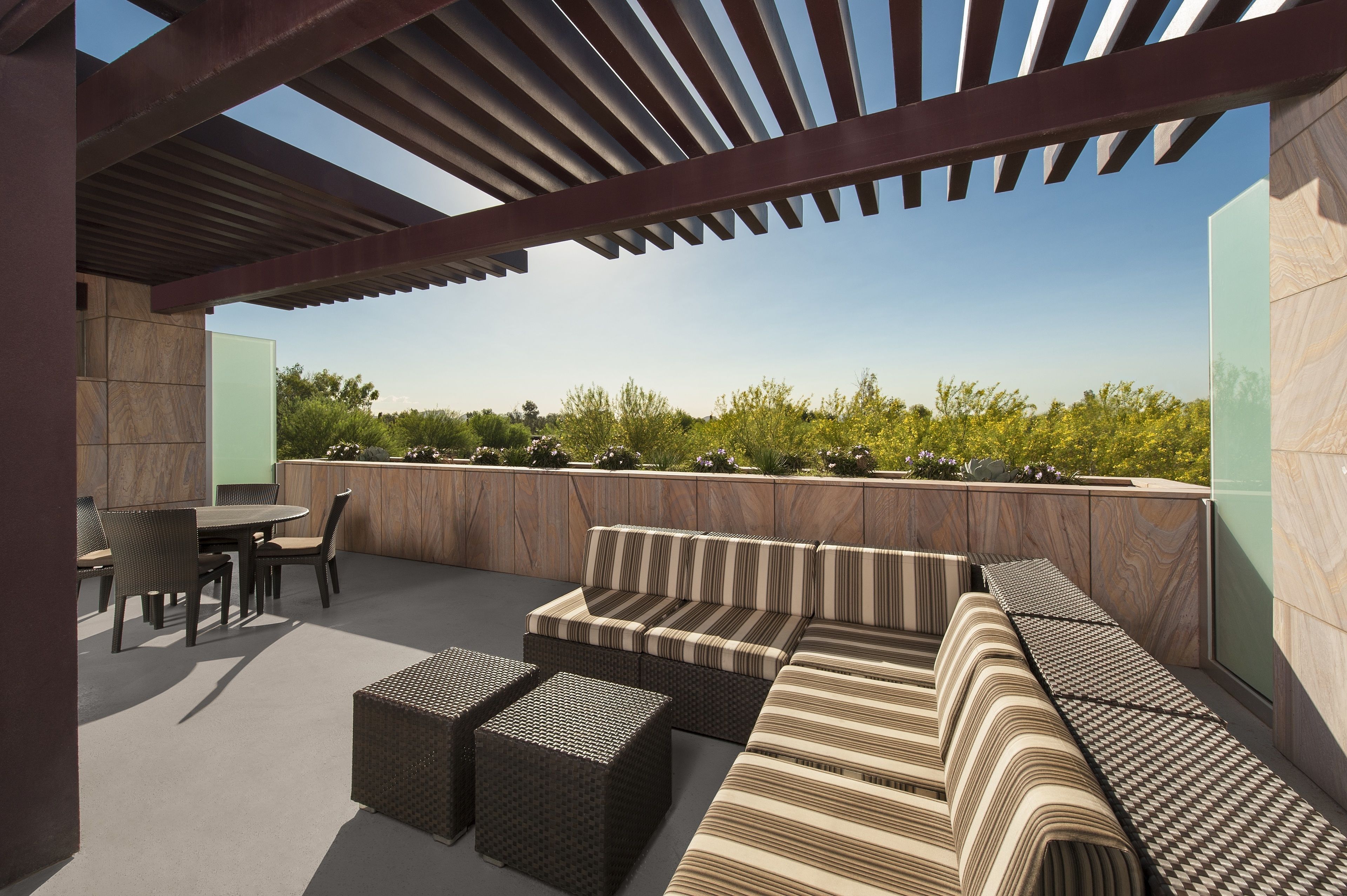 An outdoor patio with a seating area, including a sofa and chairs, and a table.