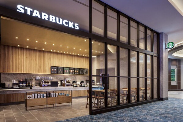 Una cafetería Starbucks con una decoración moderna, una barra y un área de asientos.
