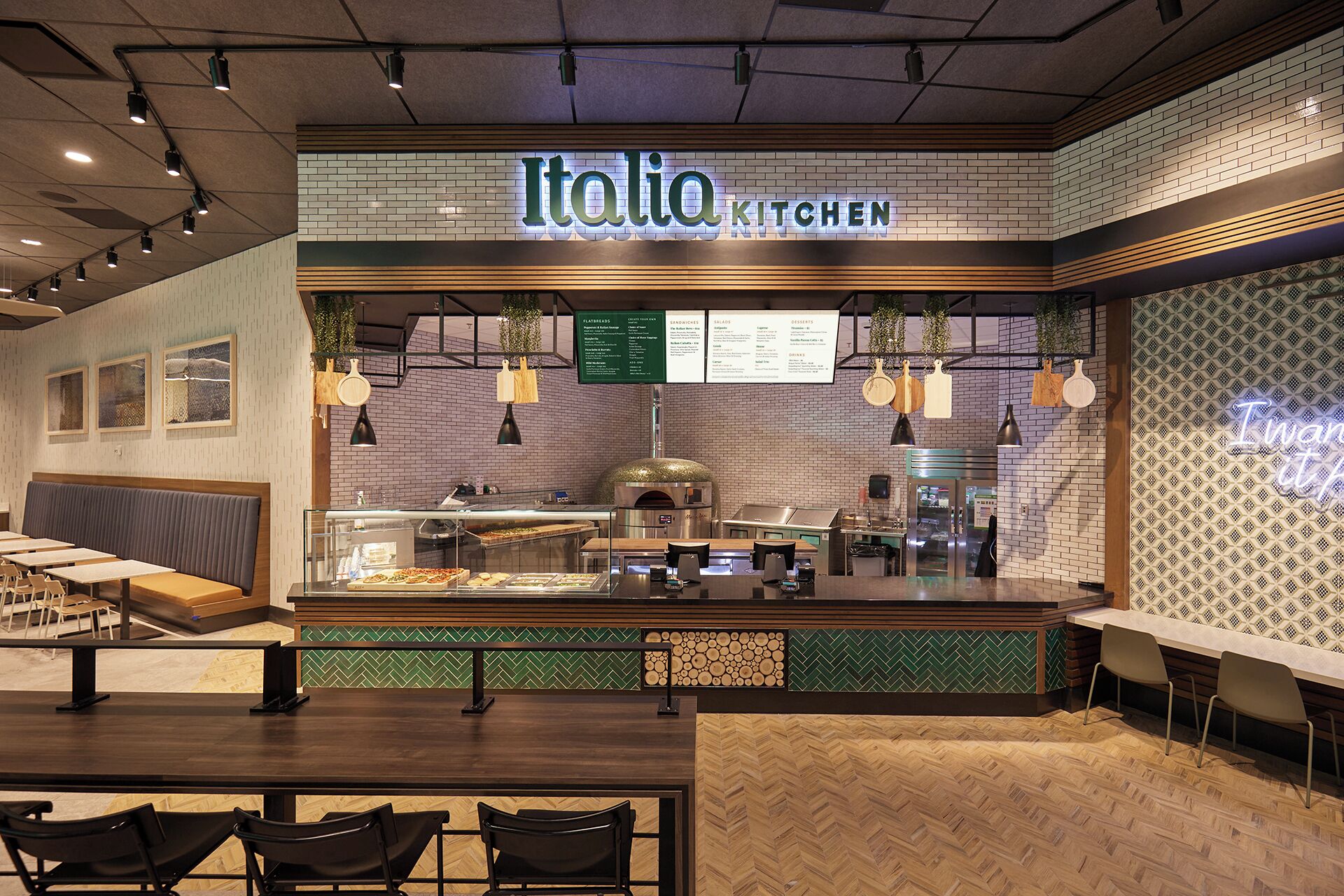 A restaurant with a brick wall, a menu board, and a counter with food display.