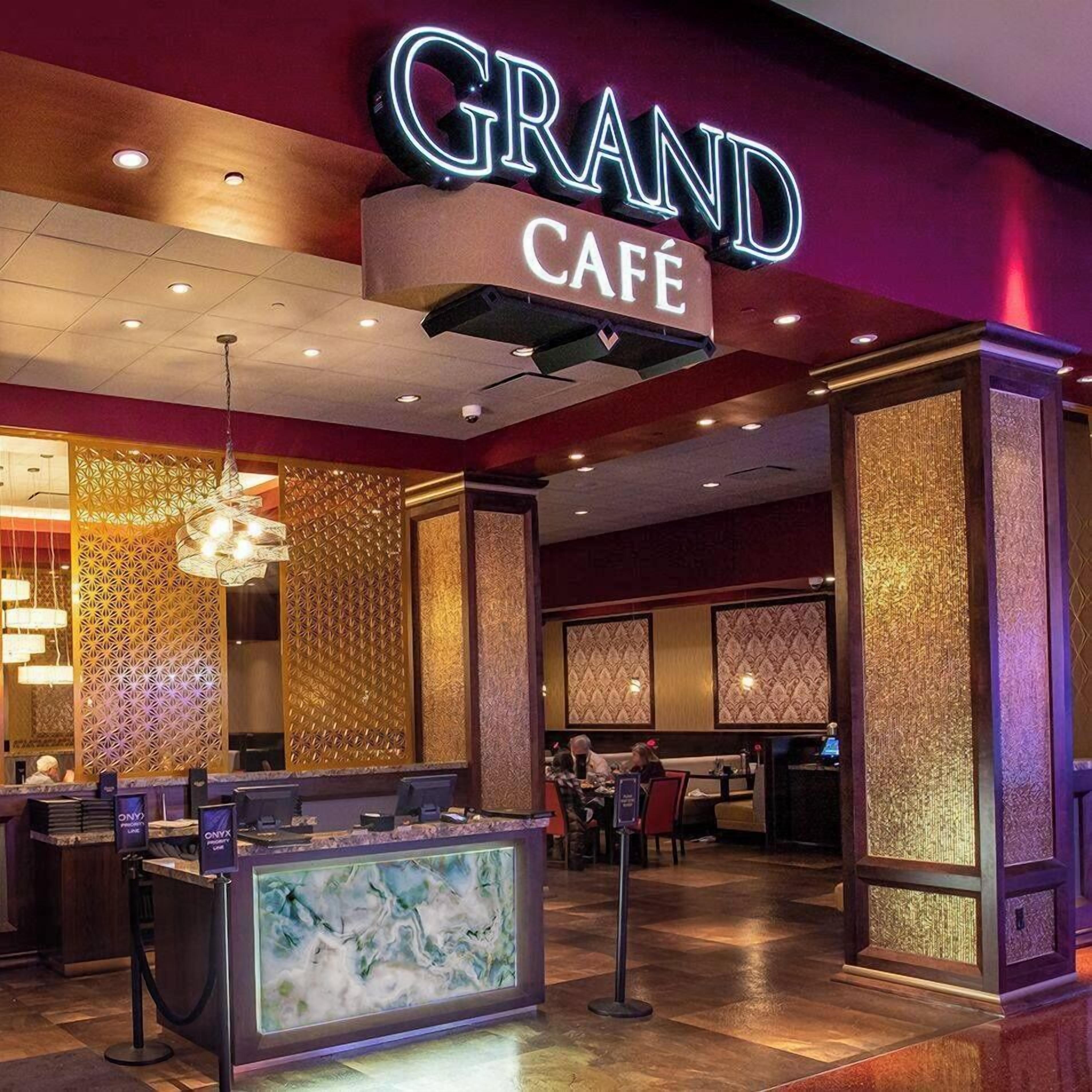 A Grand Café with a modern interior, including a reception desk and seating area.