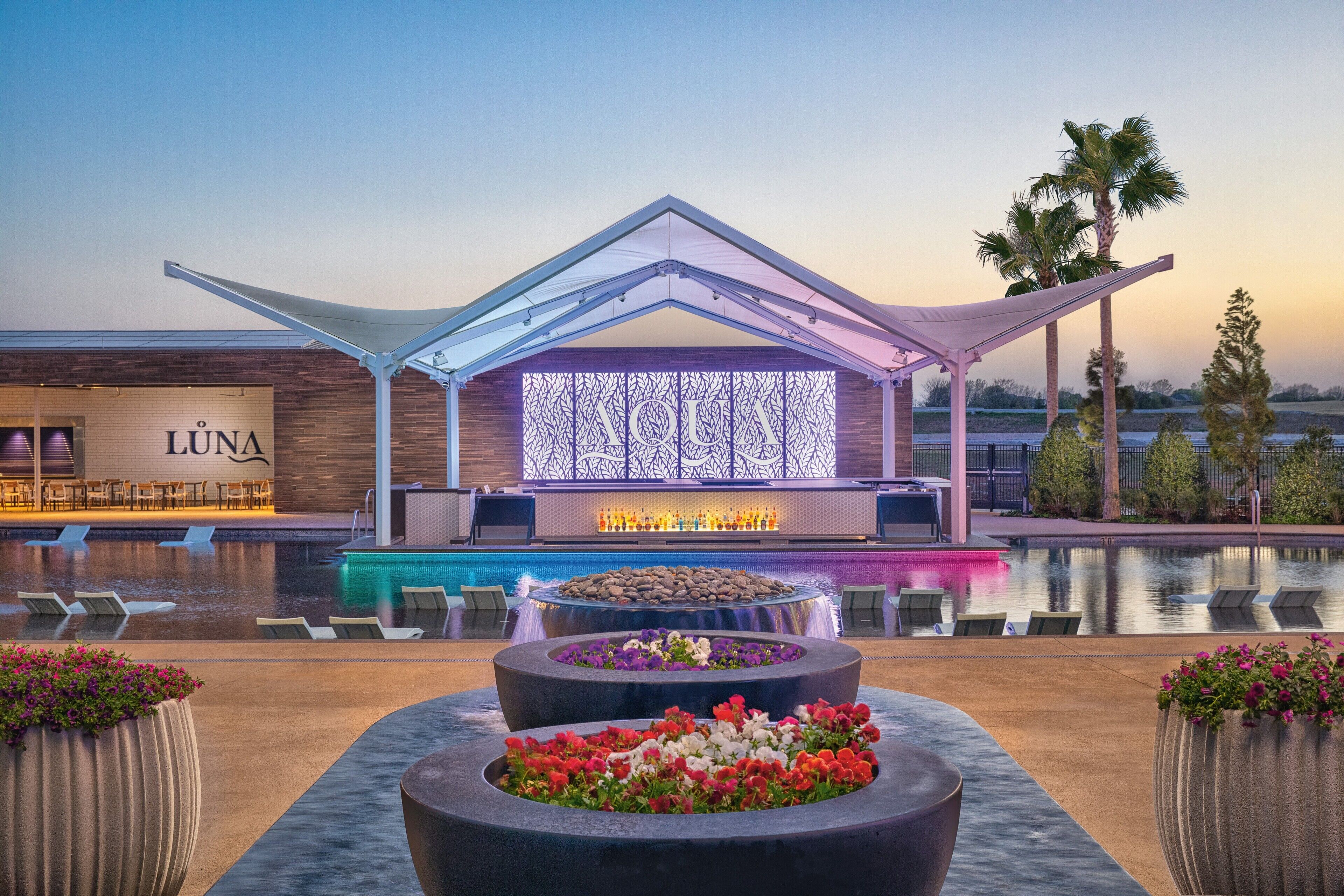 A modern hotel with a pool, outdoor seating, and a prominent 'LUNA' sign.