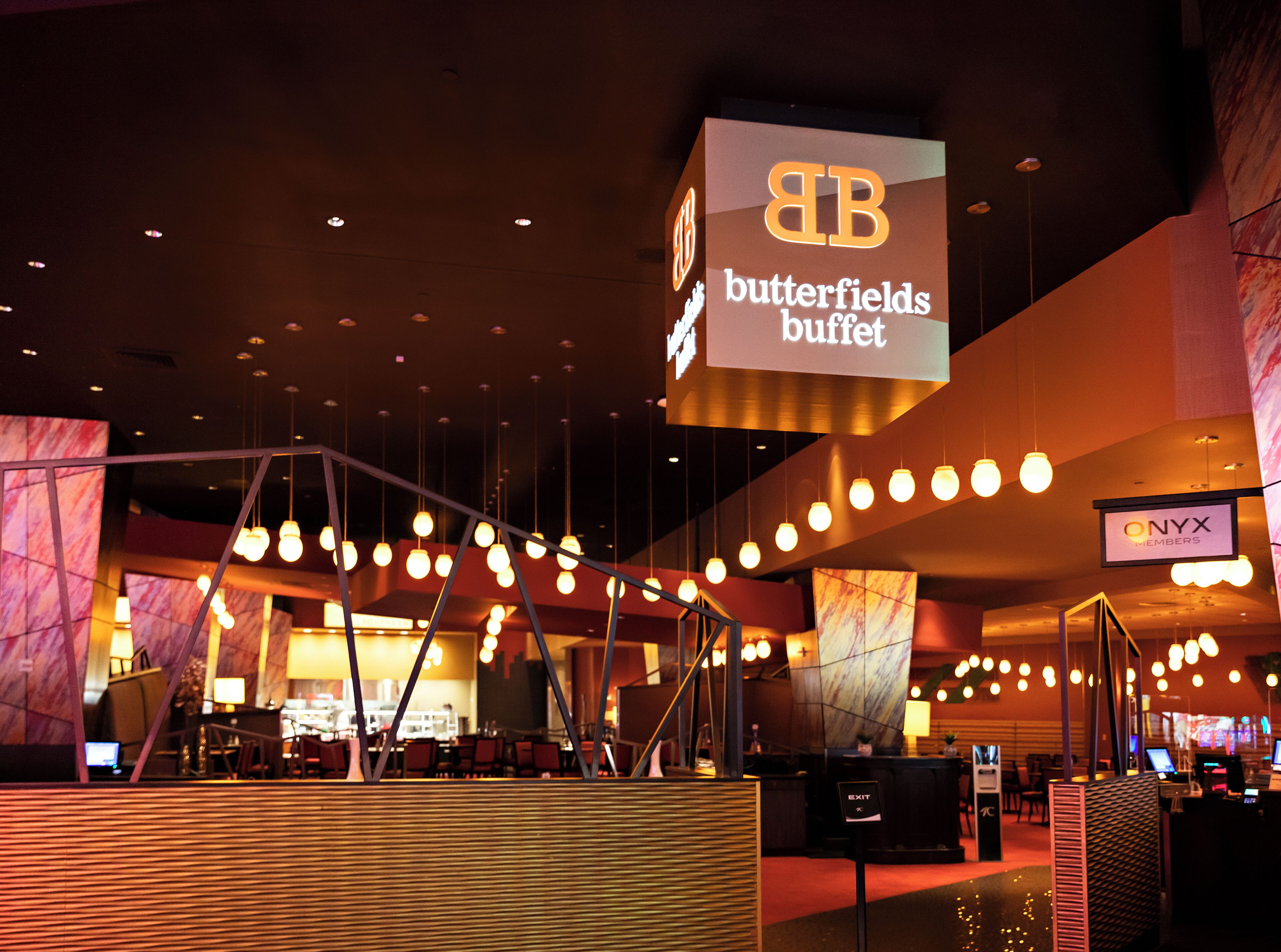 A hotel lobby with a large sign for the Butterfields Buffet, a reception desk, and a sign for Onyx Members.