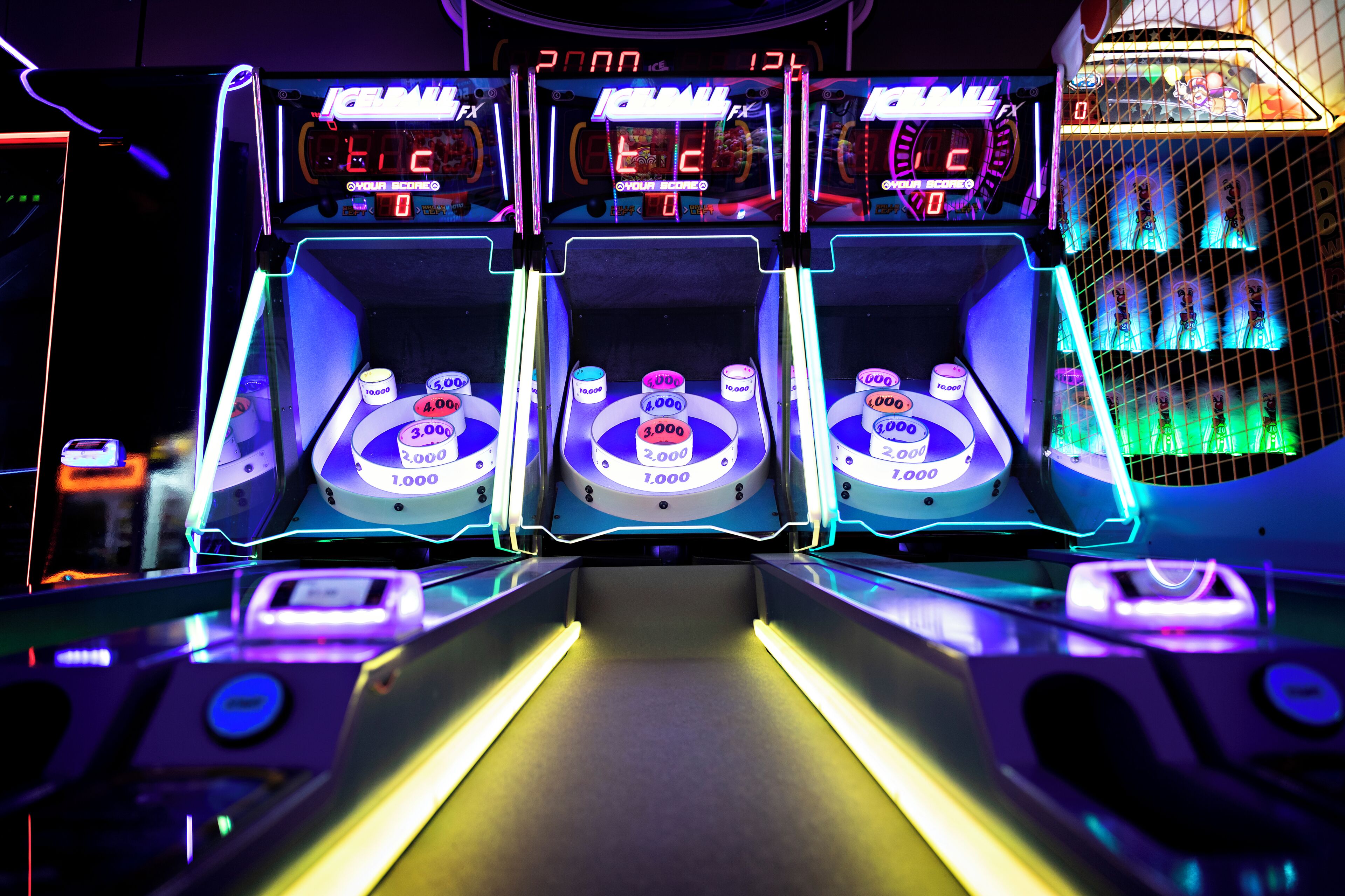 A claw machine arcade game with multiple prize levels and a digital scoreboard.