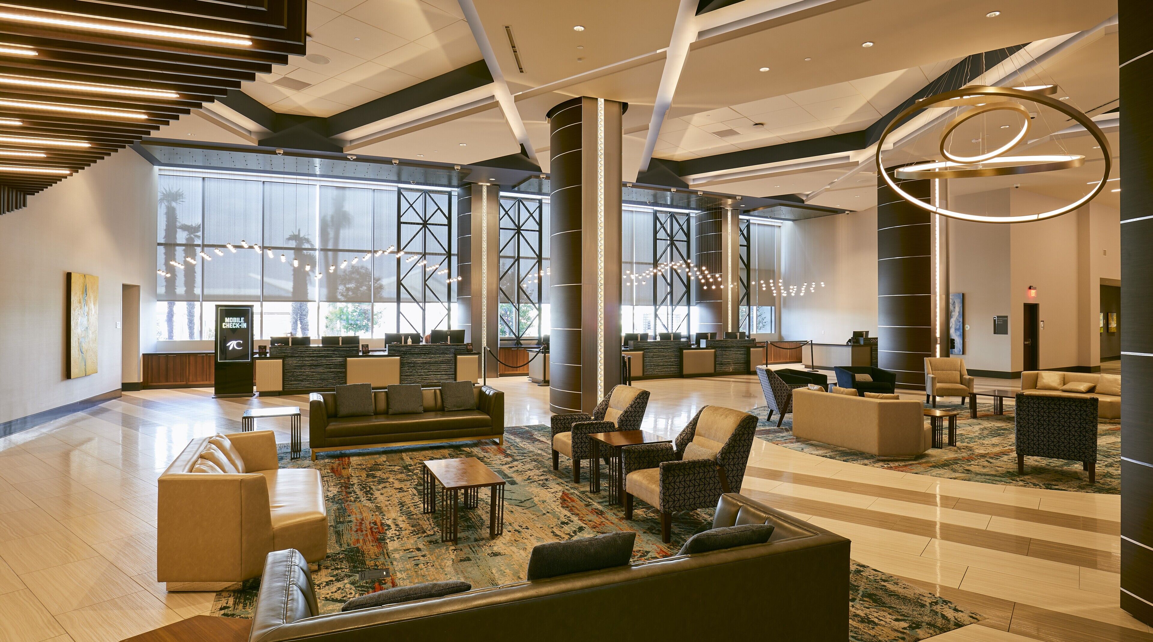 A spacious lobby with seating areas, a reception desk, and large windows.