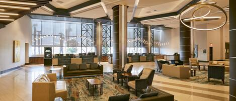 A spacious lobby with seating areas, a reception desk, and large windows.