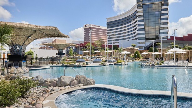 A hotel with a swimming pool, a hot tub, and a thatched structure. - Choctaw Casino & Resort Durant, a Wyndham Grand Hotel (Durant)