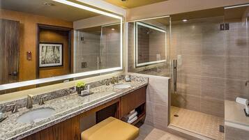 Un bagno moderno con due lavandini, uno specchio grande e una cabina doccia.