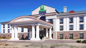A hotel with a prominent sign, a covered entrance, and a brick facade.