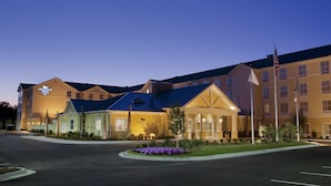 A hotel with a modern design, featuring a prominent entrance with a covered area and a flagpole. - Homewood Suites Wilmington/Mayfaire (Wilmington)