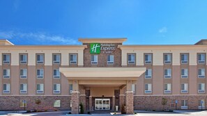 A Holiday Inn Express & Suites building with a brick facade, multiple windows, and a clear blue sky. - Holiday Inn Express & Suites Topeka North by IHG (Topeka)