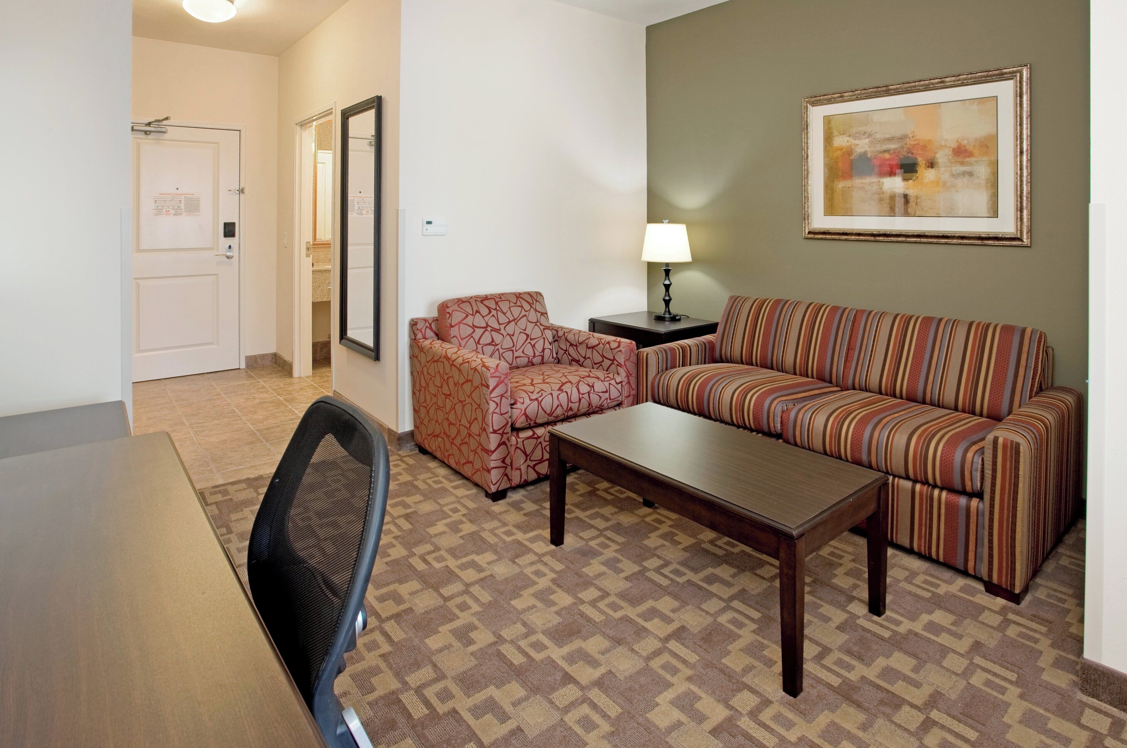 Una sala de estar amoblada con sofá, sillón, mesa de centro y mesa de comedor.