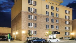 A multi-story hotel with a yellow facade, multiple windows, and a visible entrance.
