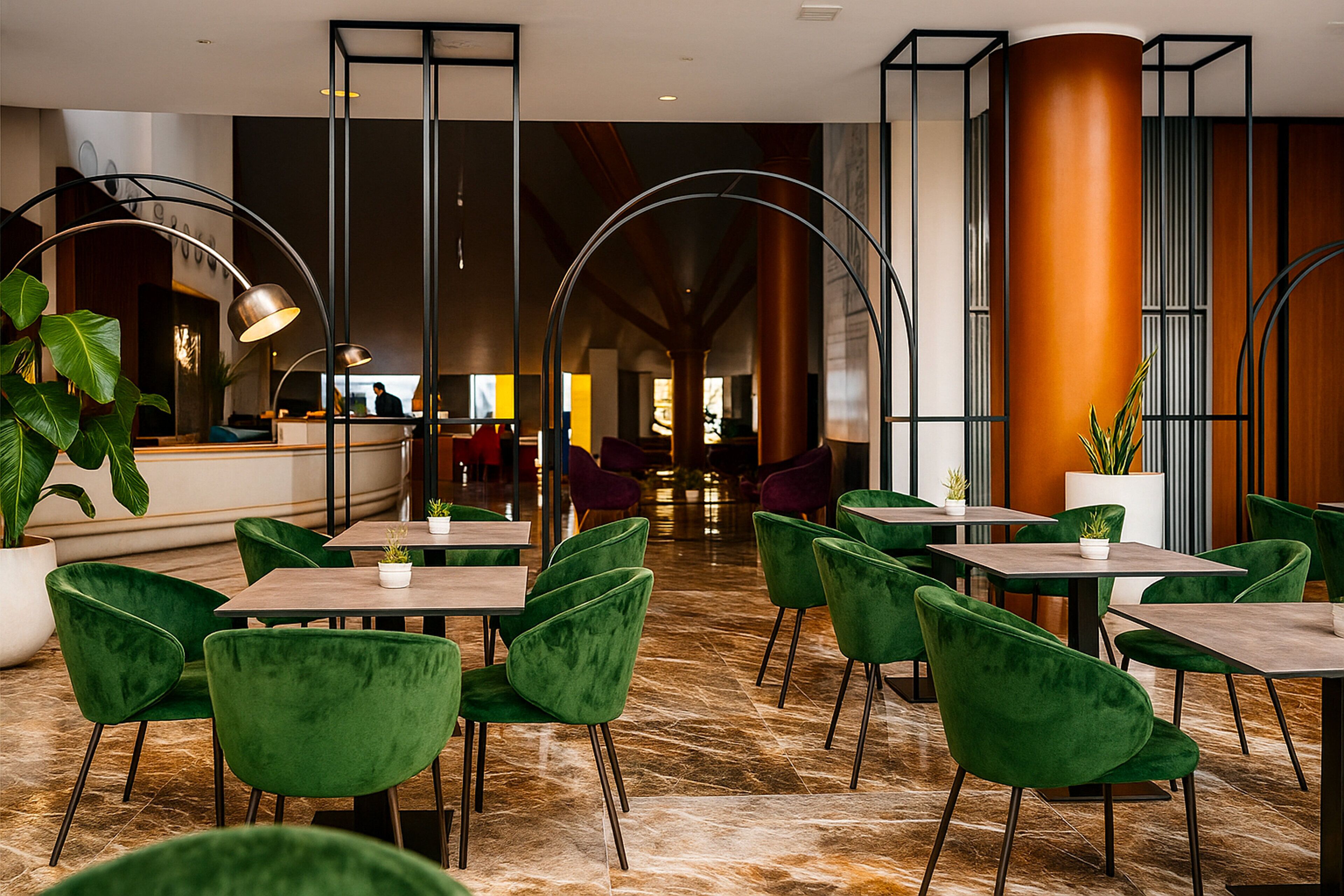 A modern hotel lobby with green velvet chairs, marble flooring, and a reception area in the background.