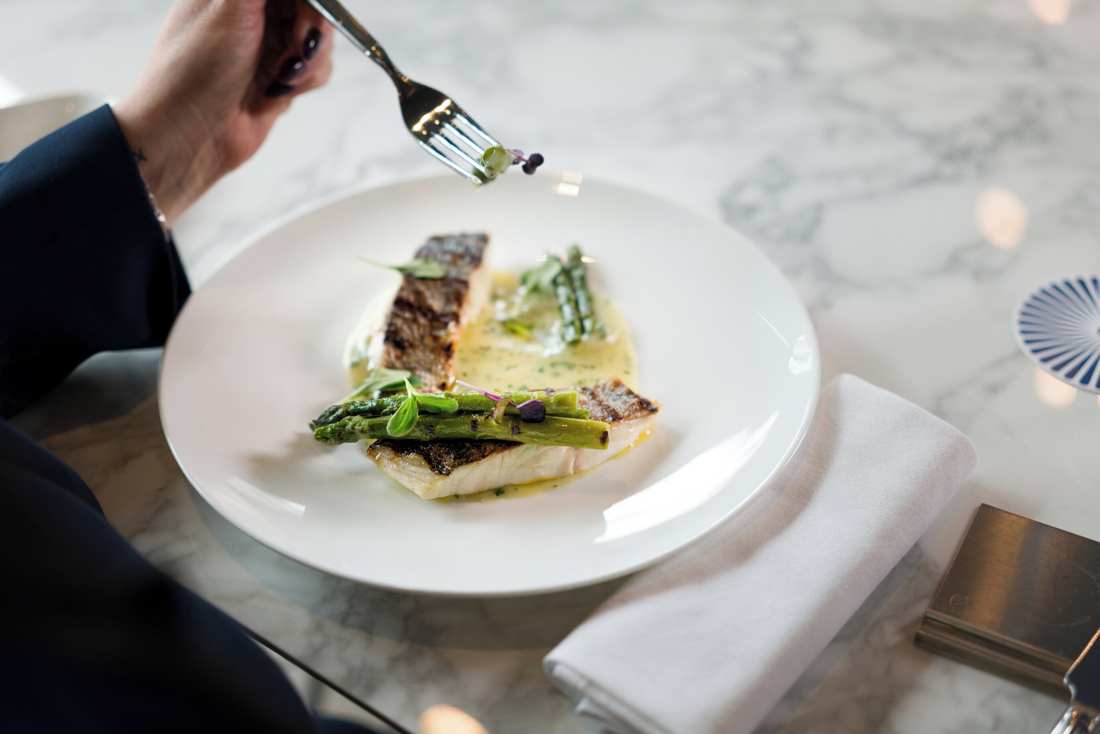 A plate of food with a fork, on a marble table.