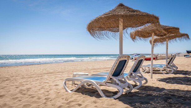 Beach chairs and thatched umbrellas on a sandy beach with the ocean in the background. - Hotel Yaramar - Adults Recommended (Fuengirola)