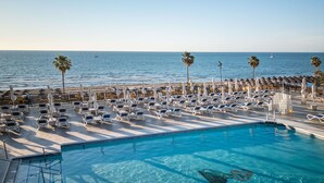 A poolside area with sun loungers and palm trees, overlooking the ocean. - Hotel Yaramar - Adults Recommended (Fuengirola)
