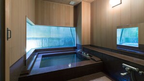 A modern sauna with a glass enclosure, wooden paneling, and a built-in bench. - Kinjohro Kanazawa (Kanazawa)