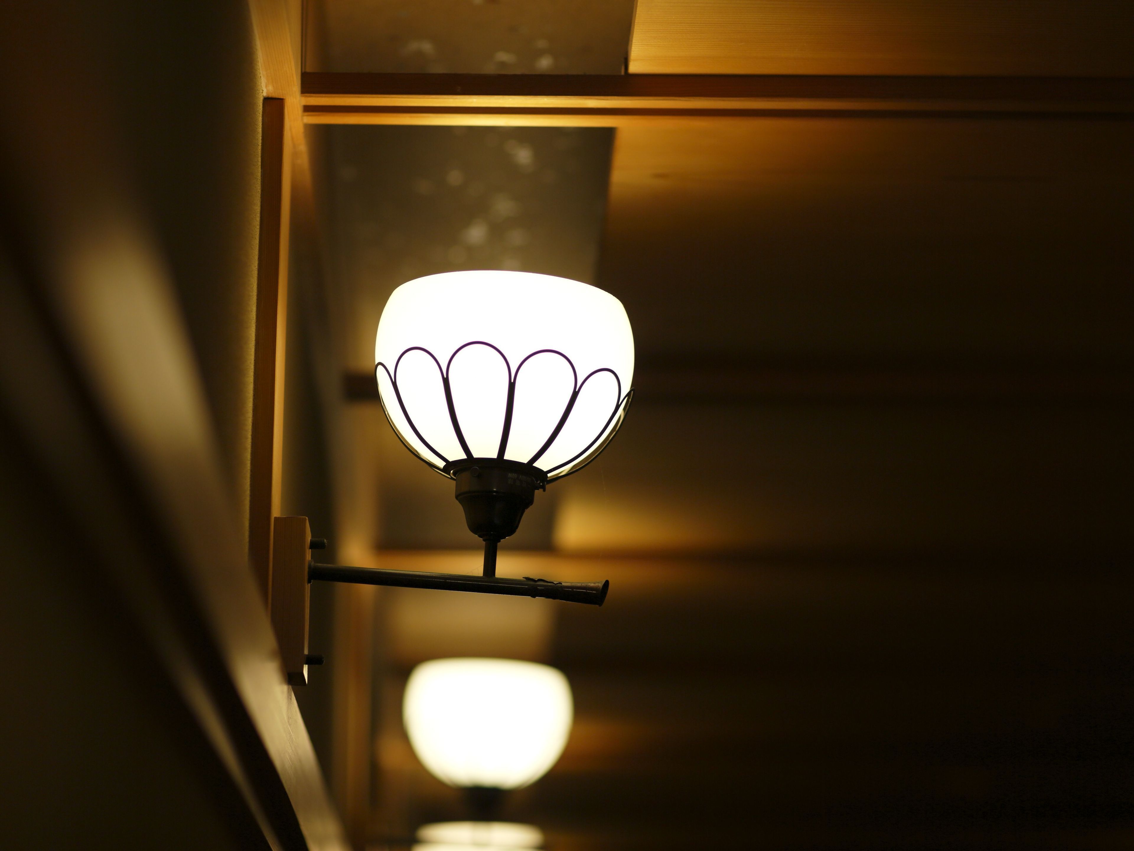 Een gang met een wandlamp.