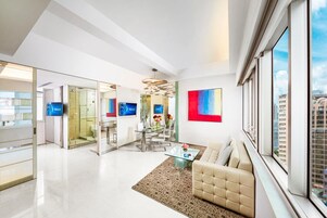 A modern living room with a sofa, a coffee table, and a large window.