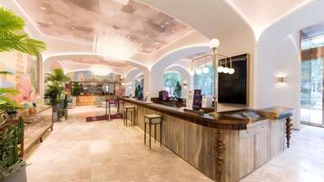 A spacious lobby with a curved reception desk, seating area, and a large window offering a view of the outdoors.