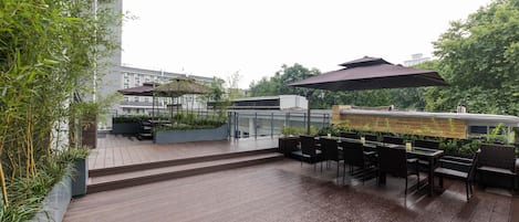 A wooden deck with outdoor seating and a pergola.