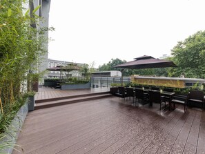 Une terrasse en bois avec des sièges d’extérieur et une pergola.