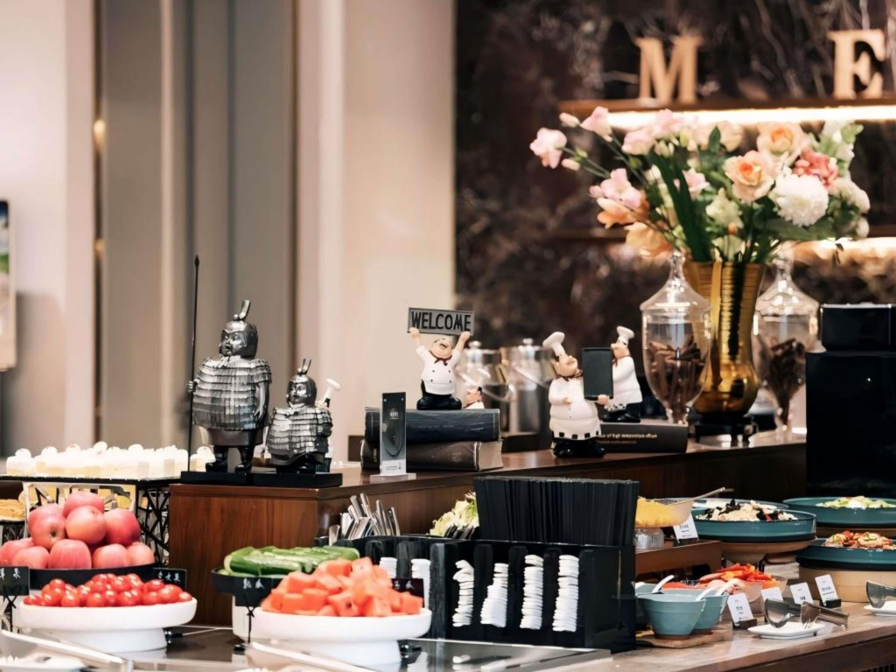 A buffet area with various food items and a welcome sign.