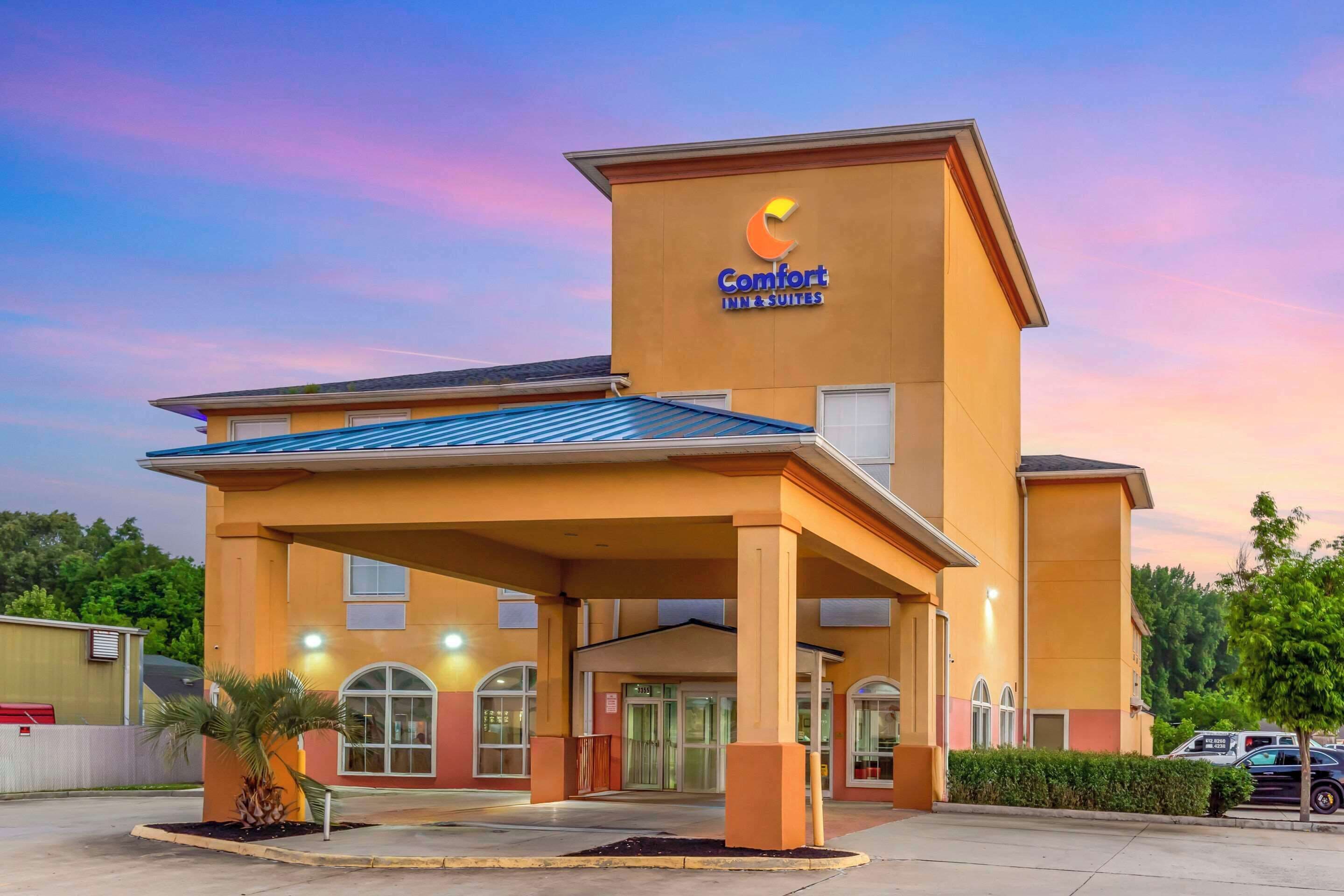 Un hotel Comfort Inn & Suites con entrada cubierta, ventanas amplias y estacionamiento.