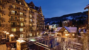 A multi-story hotel with balconies, a pool area, and snow-covered surroundings. - Four Seasons Resort and Residences Vail (Vail)