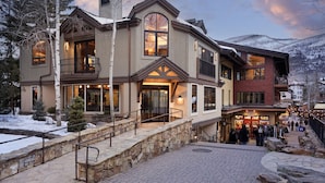 A multi-story hotel with a stone facade, large windows, and a balcony.