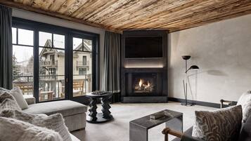 Una sala de estar moderna con chimenea, ventanas amplias y vistas a un edificio.