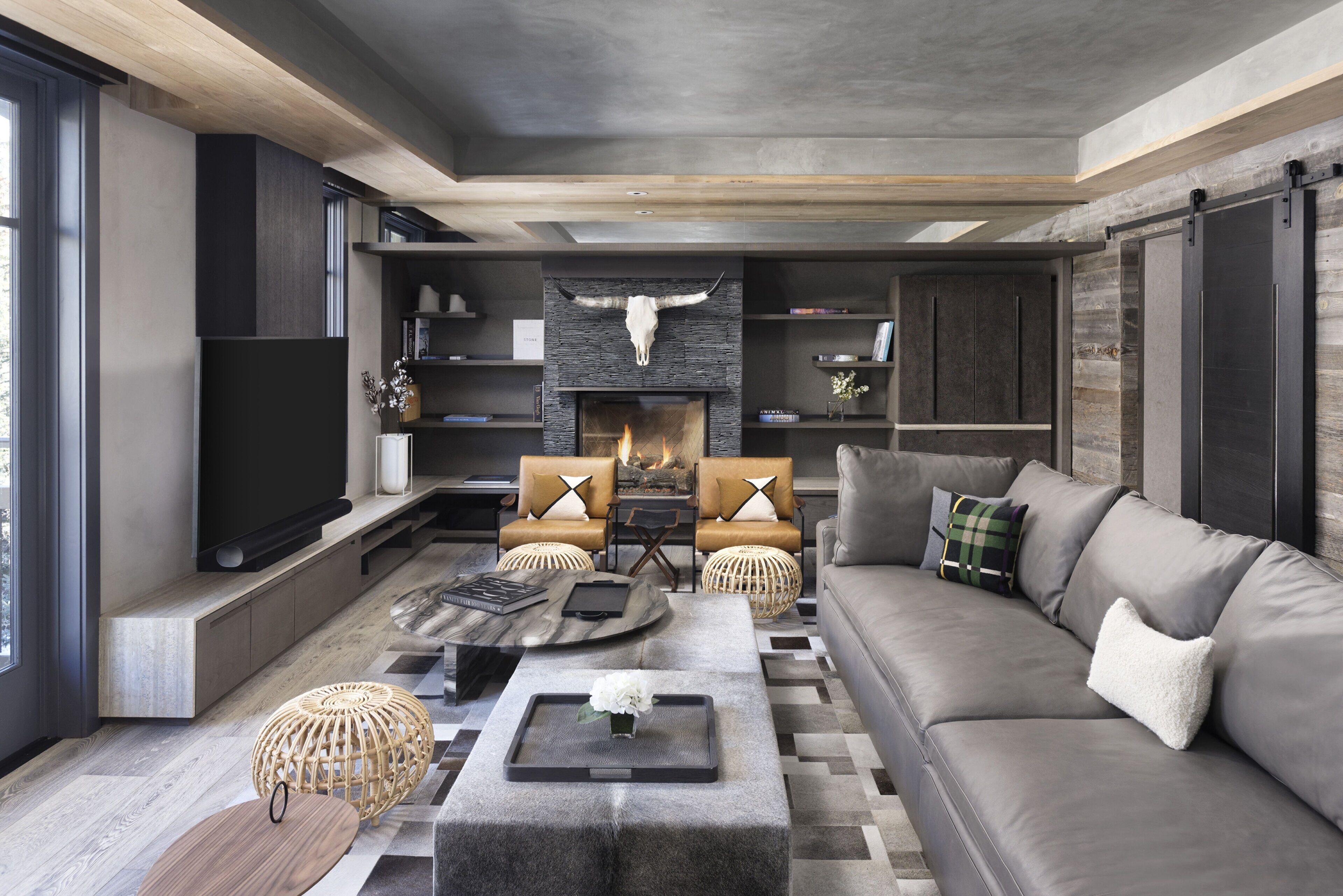 Una sala de estar moderna con chimenea, sofás y una mesa de centro.