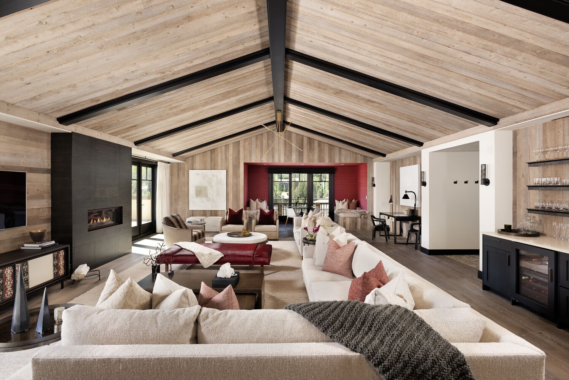 A spacious living area with a high ceiling, a fireplace, and a seating arrangement including a sofa and chairs.