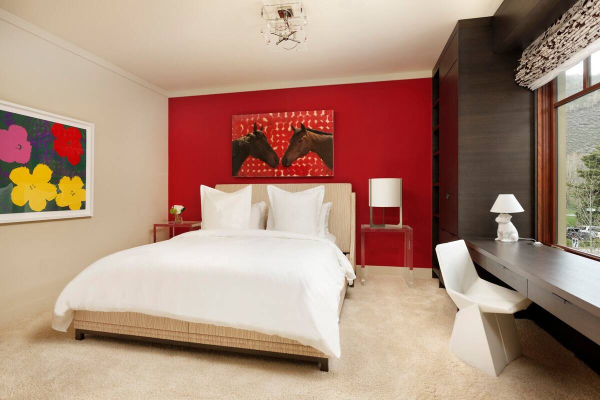 Ein Hotelzimmer mit einem großen Bett, einem Schreibtisch und einem Fenster mit Blick.