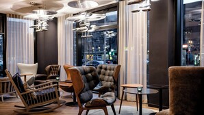 A modern interior with leather chairs, a wooden rocking chair, and a small table. - Motel One Hamburg-Alster (Hamburg)