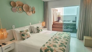 A bedroom with a bed, nightstands, a wall art piece, and a balcony with a potted plant. - Hotel Paradiso del Sol (Cabo Frio)