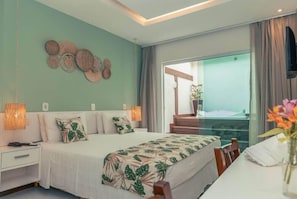 A bedroom with a bed, bedside tables, a wall art piece, a window with curtains, and a view of the outside. - Hotel Paradiso del Sol (Cabo Frio)