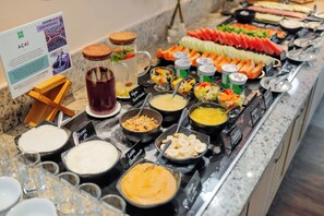 A buffet with various food items and condiments.