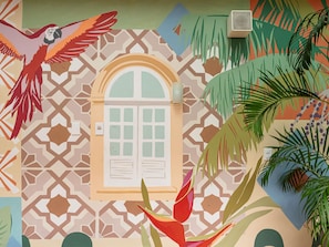 A room with a patterned wall, a window with shutters, a wall socket, and a plant. - ibis Styles Manaus - Stay in the Historic Center, 15 minutes from the Amazonas Convention Center (Manaus)