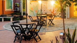 An outdoor patio with a table and chairs, surrounded by potted plants and a tree. - ibis Styles Manaus (Manaus)