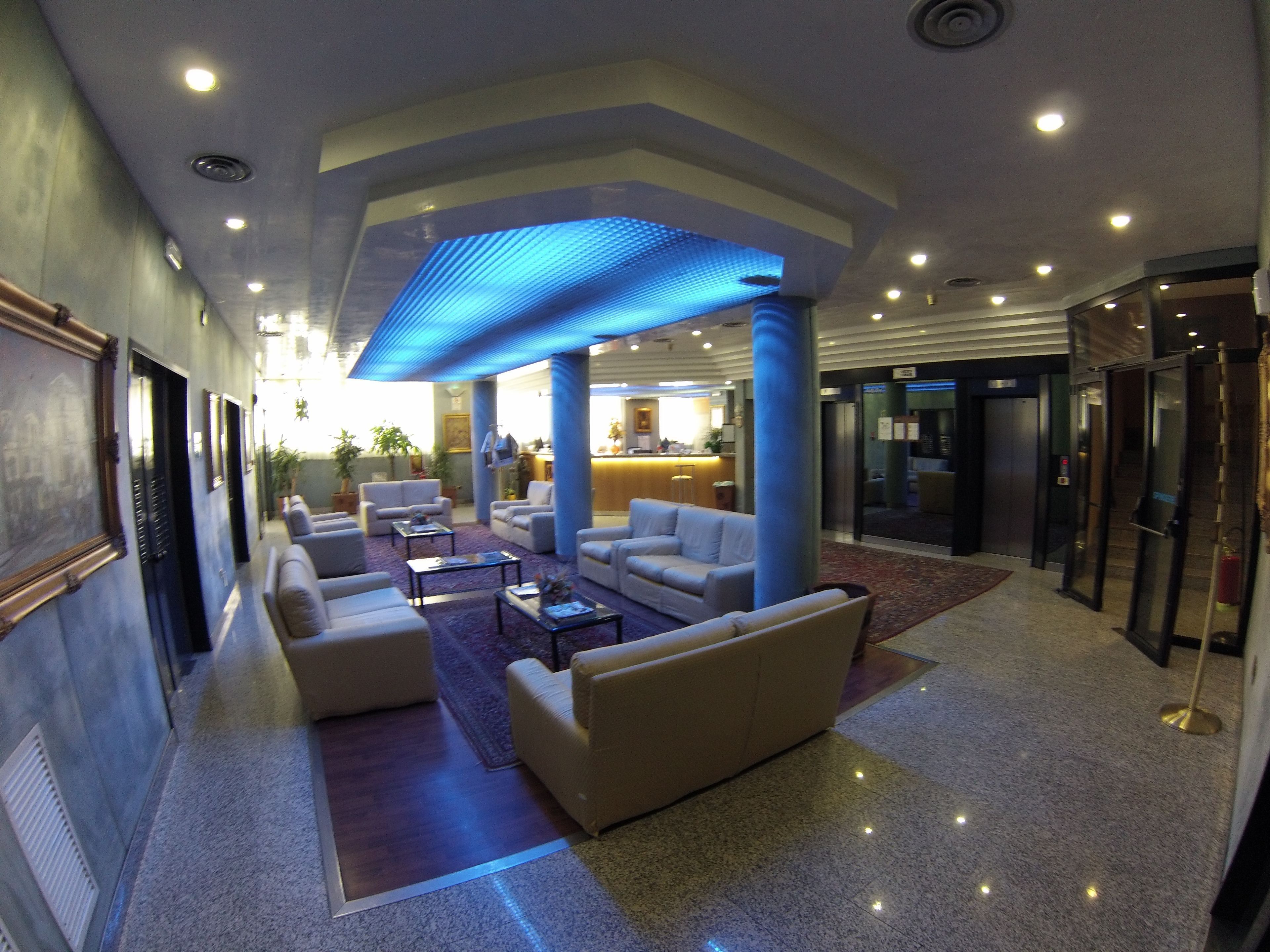 A lobby with a reception desk, seating area, and elevators.