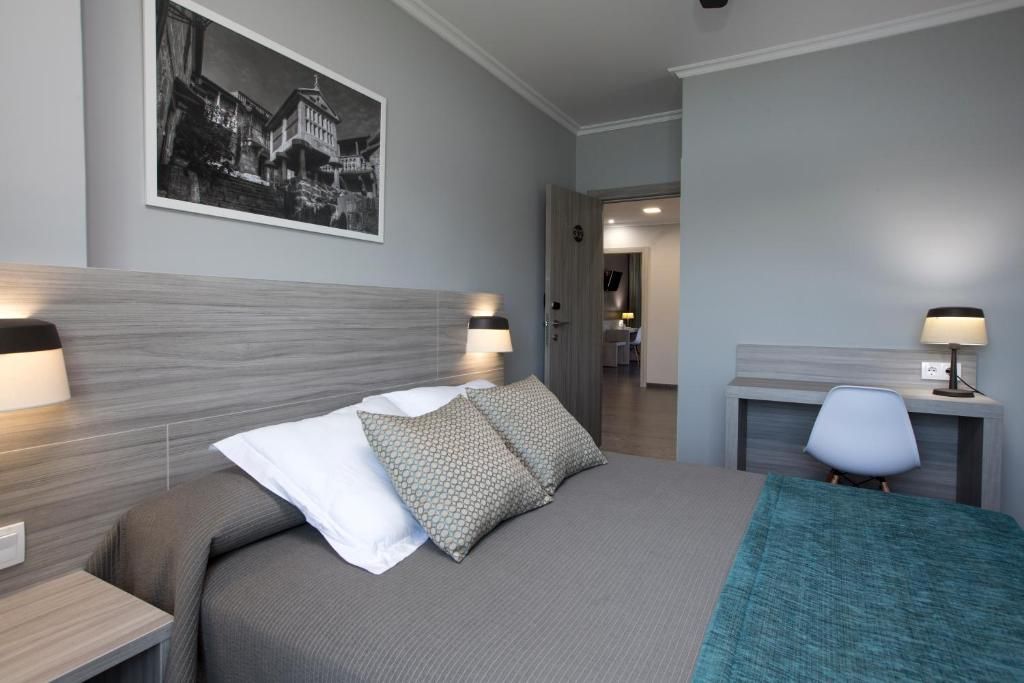 Une chambre d’hôtel avec un lit, des tables de chevet, un bureau et une chaise.