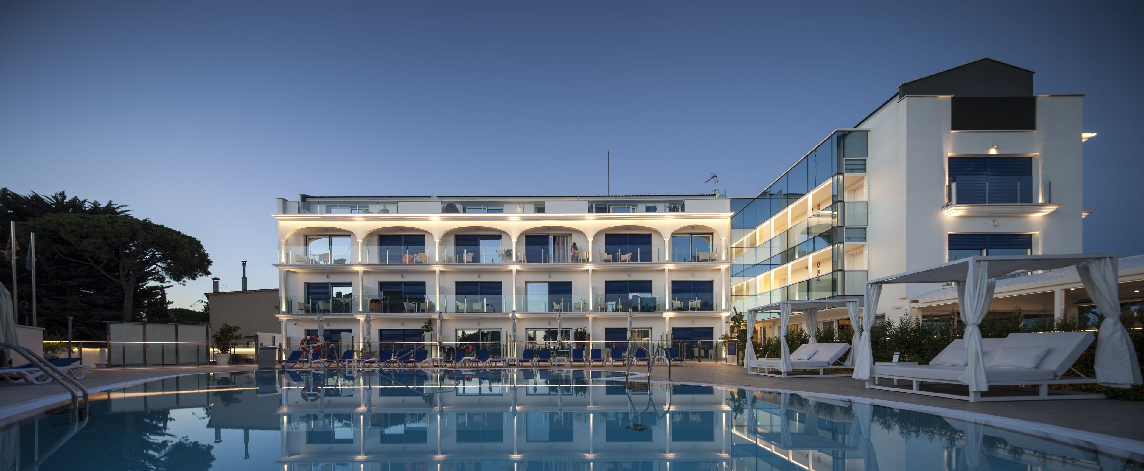 Un hotel con piscina, varios balcones y un diseño arquitectónico moderno.