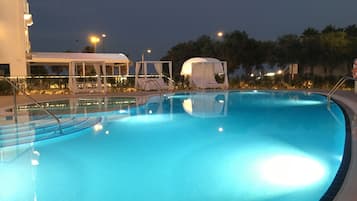 Piscine couverte, piscine extérieure, parasols de plage, chaises longues