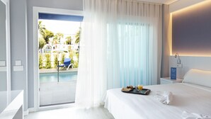 Habitación de hotel con cama, bandeja de desayuno, mesita de noche y vistas a una piscina y zona de estar exterior.