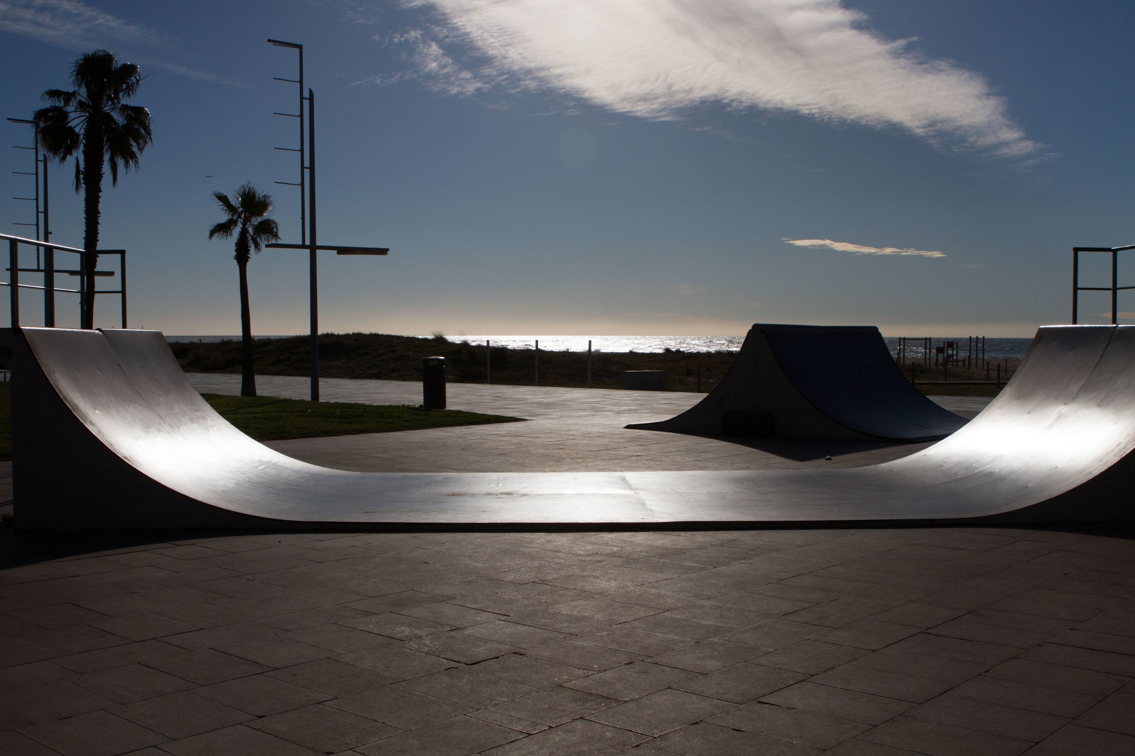 A skate park with ramps and a clear sky.