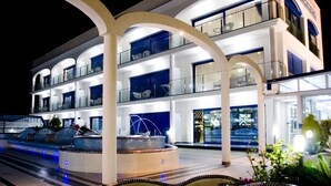 Un hotel de varios pisos con un patio central, balcones y un diseño arquitectónico moderno.