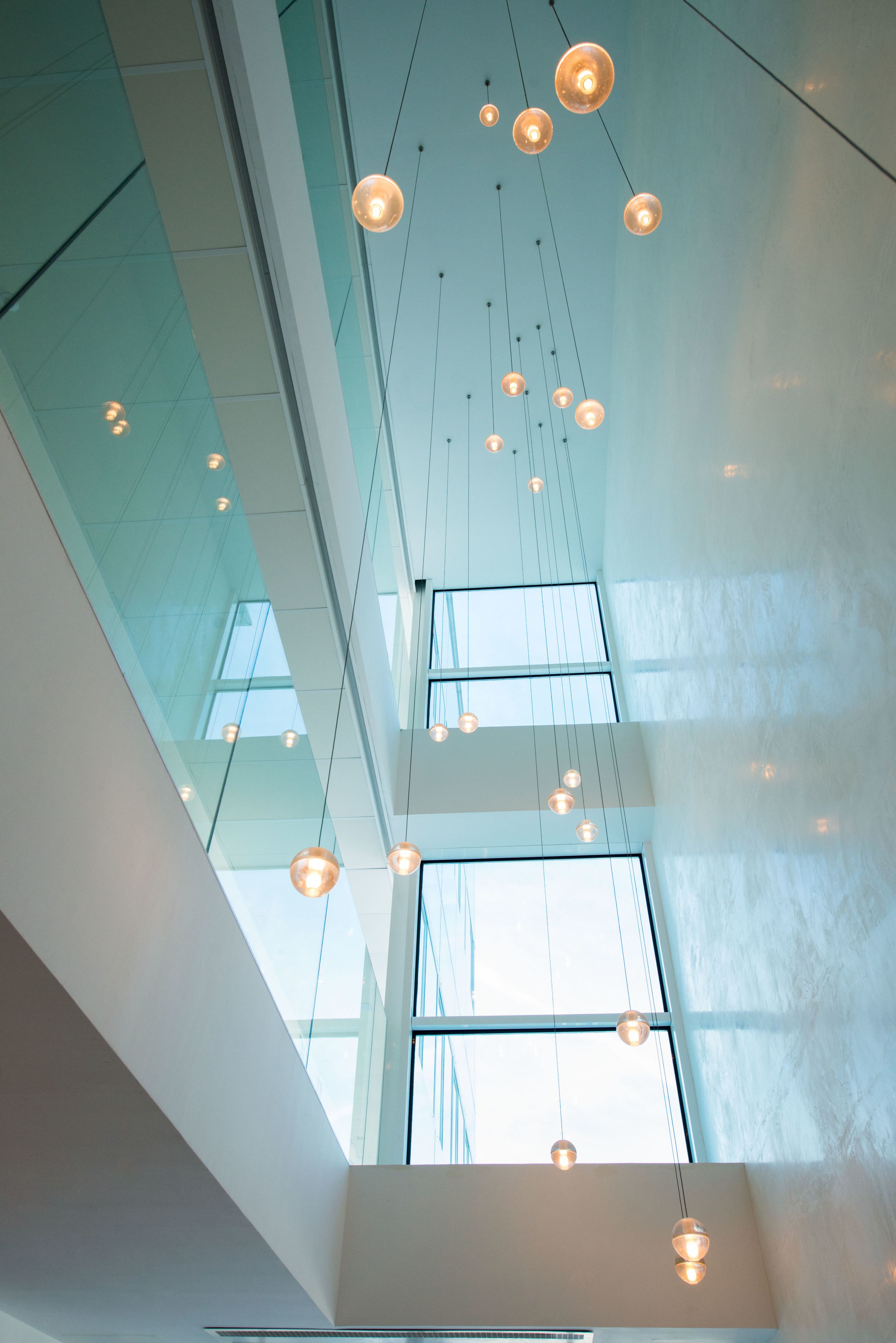 A modern interior with hanging pendant lights and large windows allowing natural light.