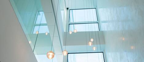 A modern interior with hanging pendant lights and large windows allowing natural light.